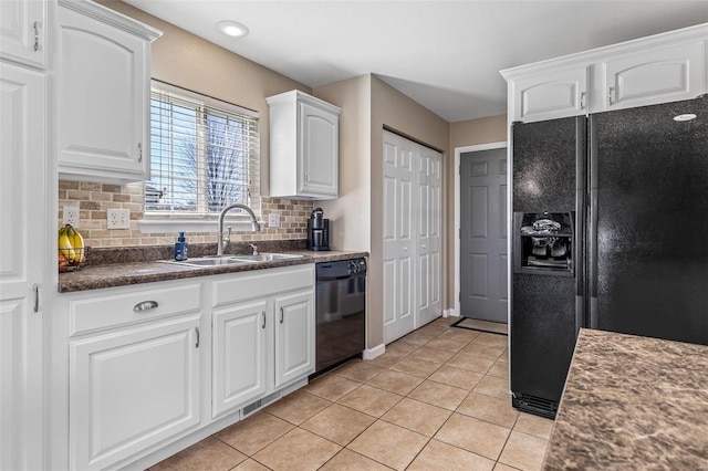kitchen featuring black appliances, a sink, dark countertops, white cabinets, and light tile patterned floors