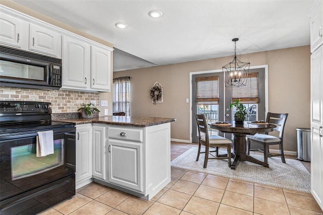 kitchen featuring light tile patterned floors, a peninsula, black appliances, white cabinets, and a chandelier