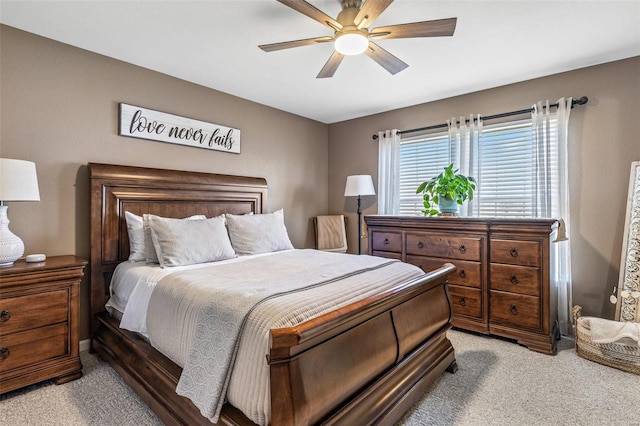 bedroom featuring light colored carpet and a ceiling fan