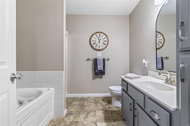 full bath with a garden tub, toilet, stone finish flooring, baseboards, and vanity