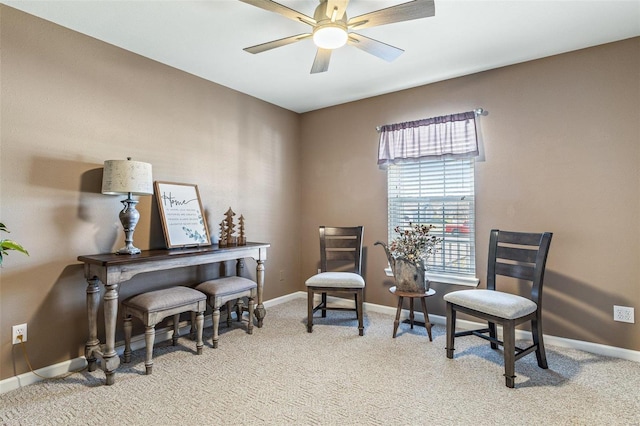 sitting room featuring a ceiling fan, baseboards, and light carpet