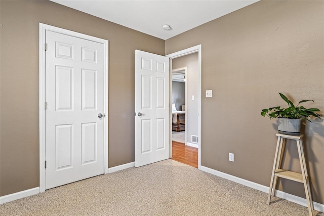 unfurnished bedroom featuring light carpet, visible vents, and baseboards