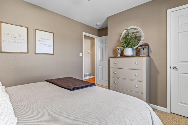 bedroom with visible vents, baseboards, and light colored carpet
