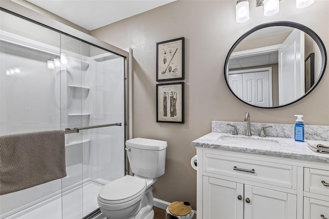 full bathroom featuring baseboards, toilet, a stall shower, and vanity