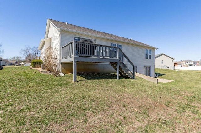 back of property featuring a deck, a yard, and stairs