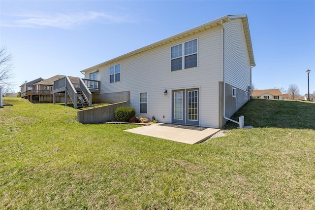 back of property featuring stairs, a patio, a lawn, and a wooden deck