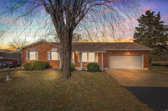 ranch-style house with a lawn, roof with shingles, concrete driveway, a garage, and brick siding