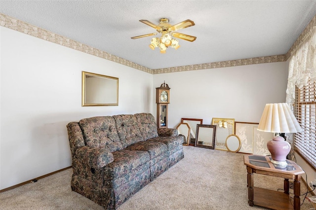 living room featuring baseboards, a textured ceiling, a ceiling fan, and carpet