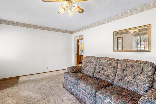 carpeted living room with baseboards, a textured ceiling, and ceiling fan