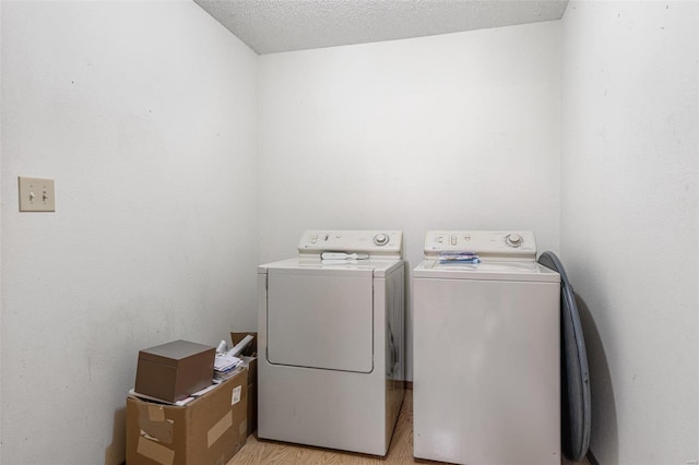 laundry room featuring light wood-style flooring, laundry area, and washing machine and clothes dryer