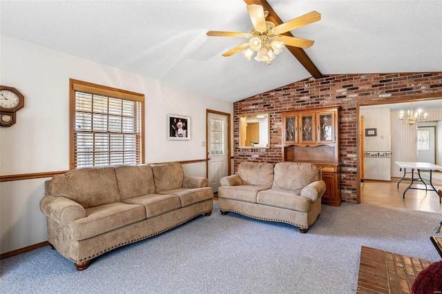 living room featuring ceiling fan with notable chandelier, a textured ceiling, carpet, brick wall, and vaulted ceiling with beams