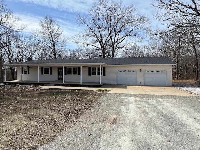 ranch-style home featuring a garage, a porch, and aphalt driveway