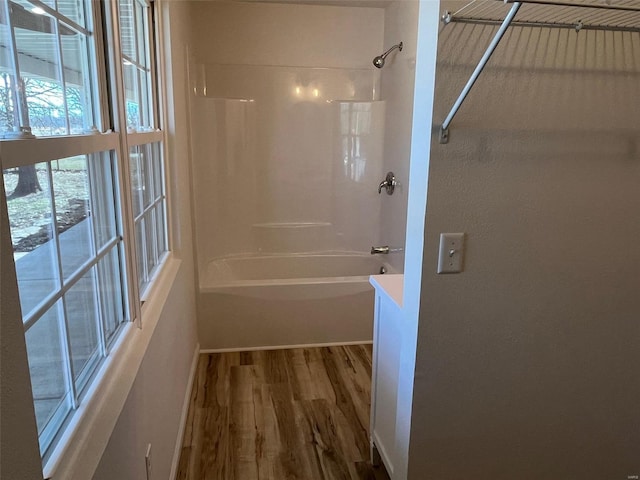 bathroom featuring wood finished floors and shower / bathtub combination