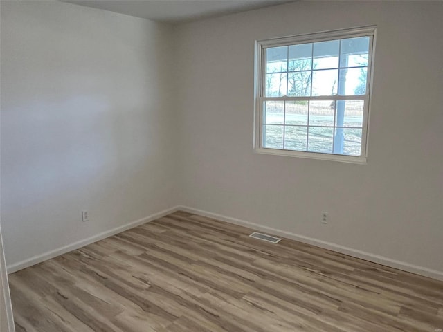 empty room with visible vents, baseboards, and wood finished floors