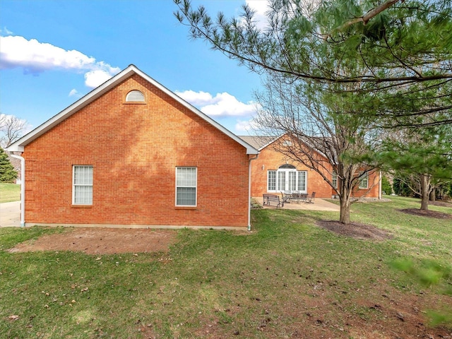 view of home's exterior featuring a yard, a patio area, and brick siding