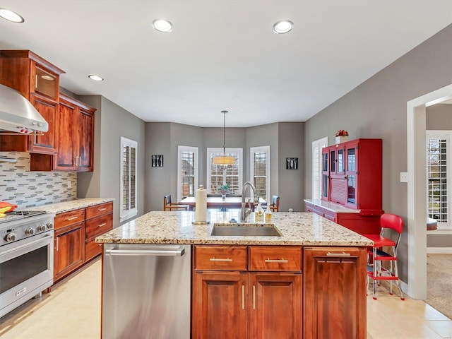 kitchen with a sink, appliances with stainless steel finishes, a center island with sink, and a healthy amount of sunlight