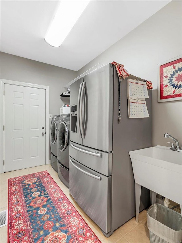 laundry room with light tile patterned floors, visible vents, laundry area, and washer and clothes dryer