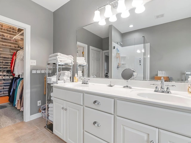 bathroom featuring tile patterned floors, walk in shower, visible vents, and a sink