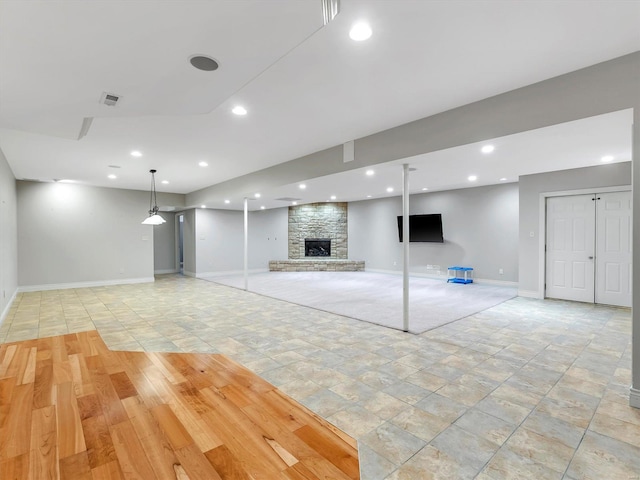 below grade area with visible vents, recessed lighting, a large fireplace, and baseboards