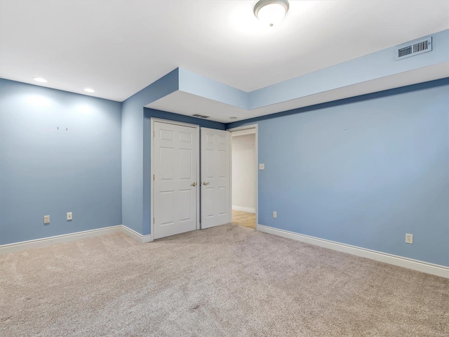 empty room with visible vents, baseboards, and carpet flooring