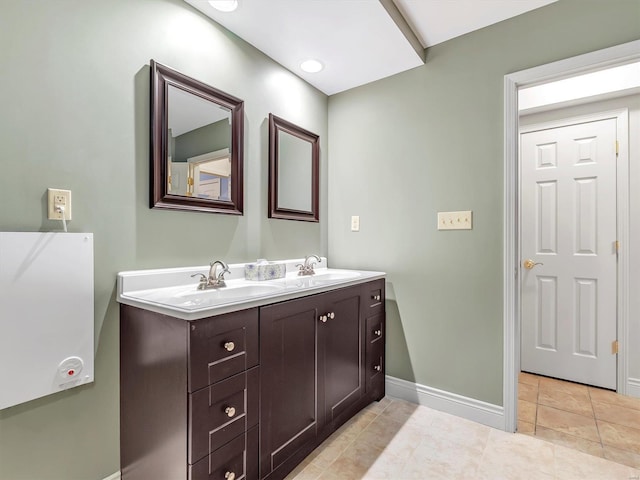 full bathroom with tile patterned floors, double vanity, baseboards, and a sink