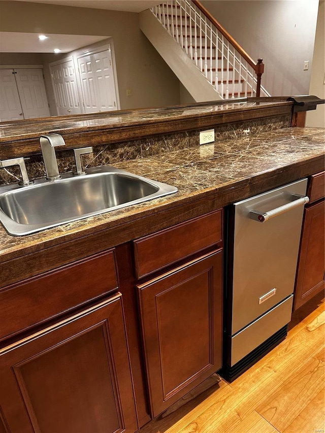 bar with dishwasher, stairway, light wood-type flooring, and a sink