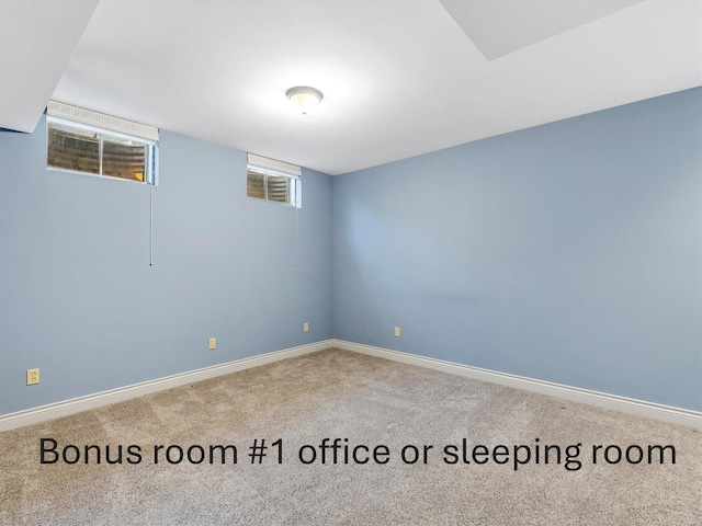 carpeted spare room featuring baseboards