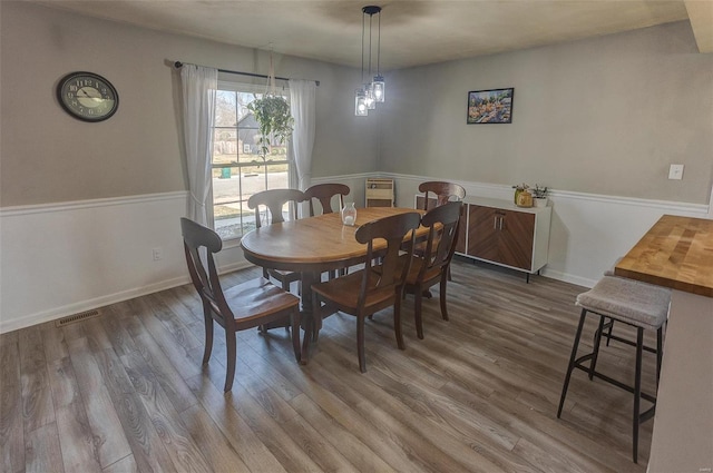 dining room featuring visible vents, baseboards, and wood finished floors