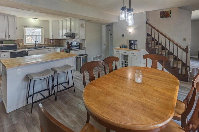 dining room with visible vents, stairway, dark wood-type flooring, and baseboards