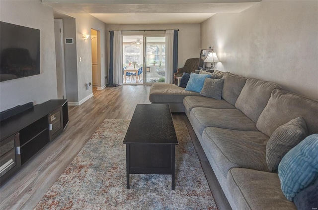 living area with baseboards and wood finished floors