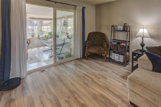 sitting room with visible vents, baseboards, and light wood-style floors