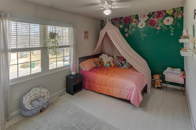 bedroom with wood finished floors, baseboards, and ceiling fan