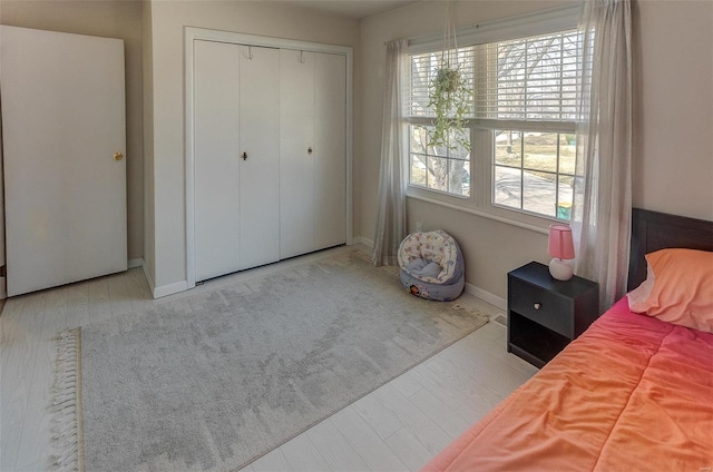 bedroom featuring a closet, baseboards, and wood finished floors