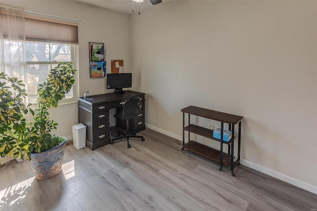 office featuring light wood-type flooring, baseboards, and ceiling fan