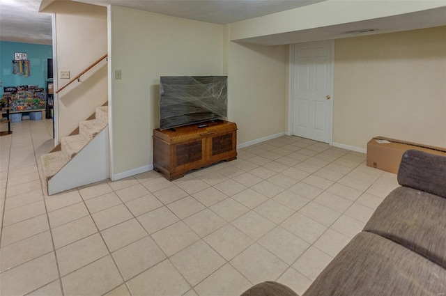 living room with stairway, baseboards, visible vents, and light tile patterned flooring