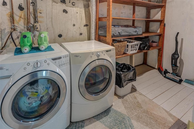 clothes washing area featuring light wood-style floors, washing machine and dryer, and laundry area