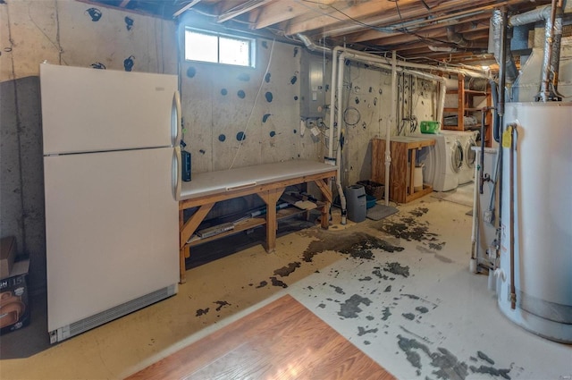 basement featuring electric panel, water heater, freestanding refrigerator, a workshop area, and independent washer and dryer