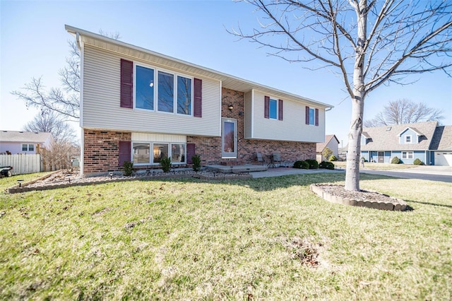 bi-level home featuring brick siding and a front lawn