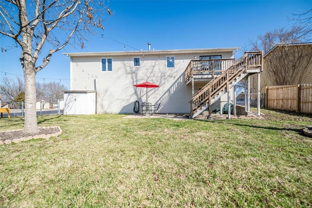 rear view of property with a yard, a deck, stairs, and fence