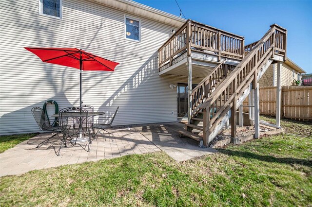 back of house featuring fence, stairway, a wooden deck, a yard, and a patio area