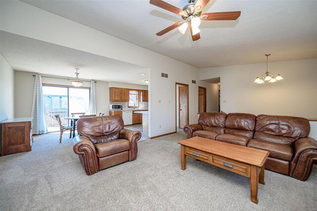 living room featuring visible vents, light carpet, baseboards, and ceiling fan with notable chandelier