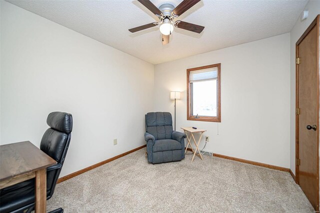 carpeted home office with a textured ceiling, baseboards, and ceiling fan