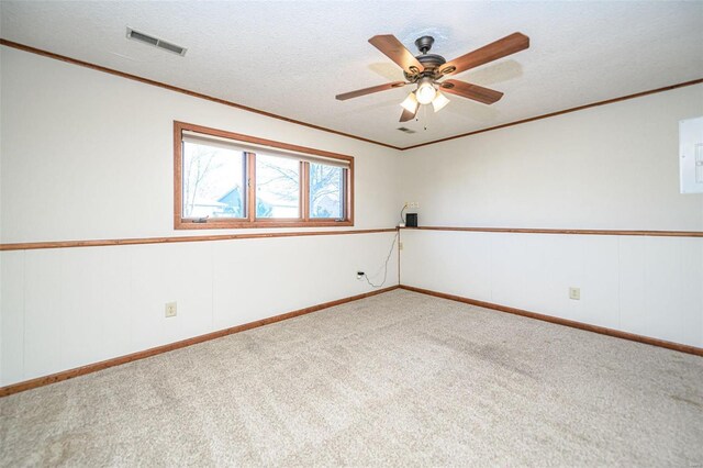 carpeted spare room with visible vents, a textured ceiling, and crown molding