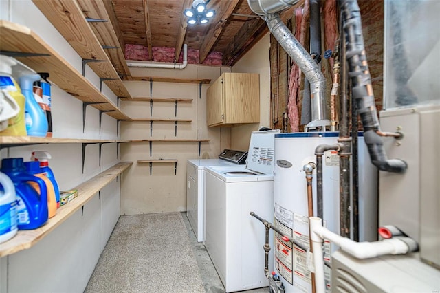 clothes washing area featuring gas water heater, laundry area, and washer and clothes dryer