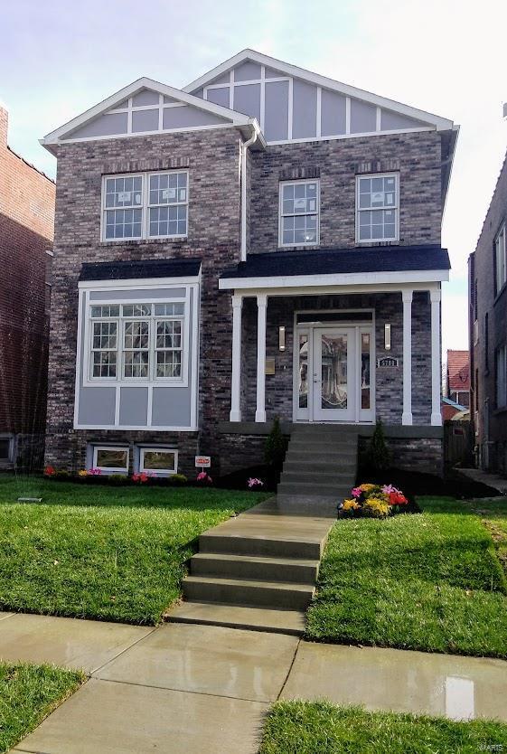 view of front of house featuring a front yard and brick siding