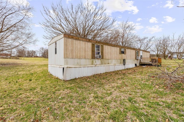 view of side of property with a yard, cooling unit, and a wooden deck