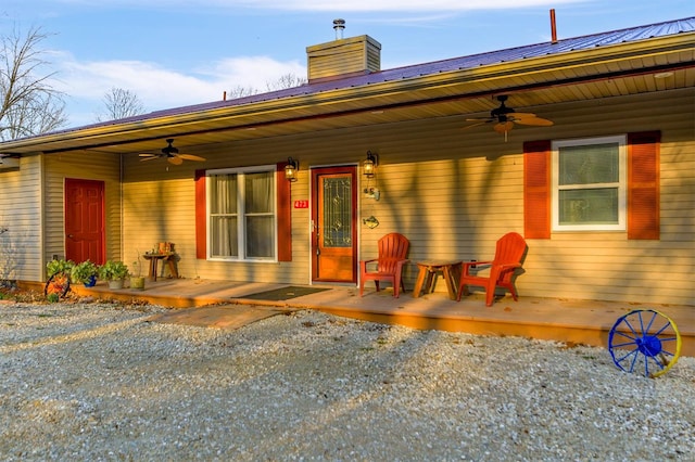 view of front of house with a porch, ceiling fan, and a chimney