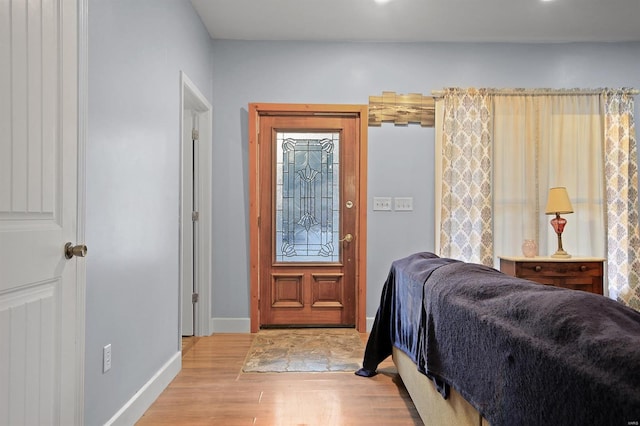 bedroom featuring baseboards and light wood finished floors