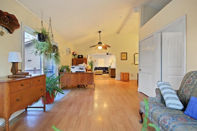 office featuring light wood-type flooring, ornamental molding, a ceiling fan, lofted ceiling with beams, and arched walkways