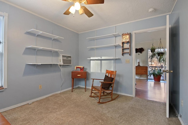 living area with a textured ceiling, crown molding, carpet floors, and ceiling fan